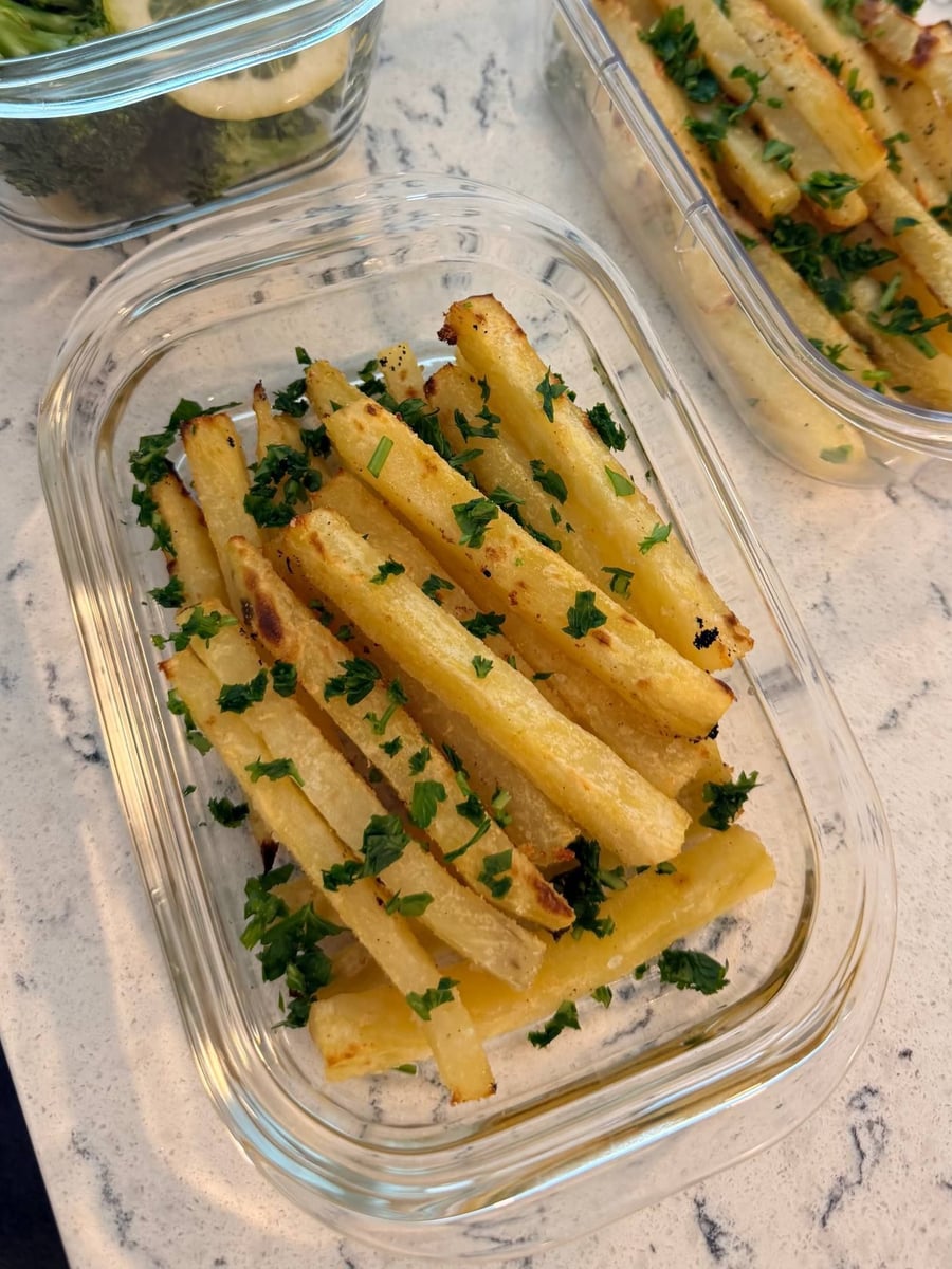 Crisped edges show on the white potato fries, broccoli and its lemon wheel sitting just behind them.