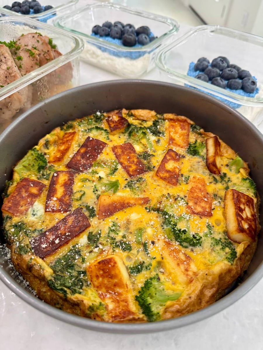 Halloumi planks browned into the egg, broccoli florets and a dusting of parmesan across a broccolini frittata.