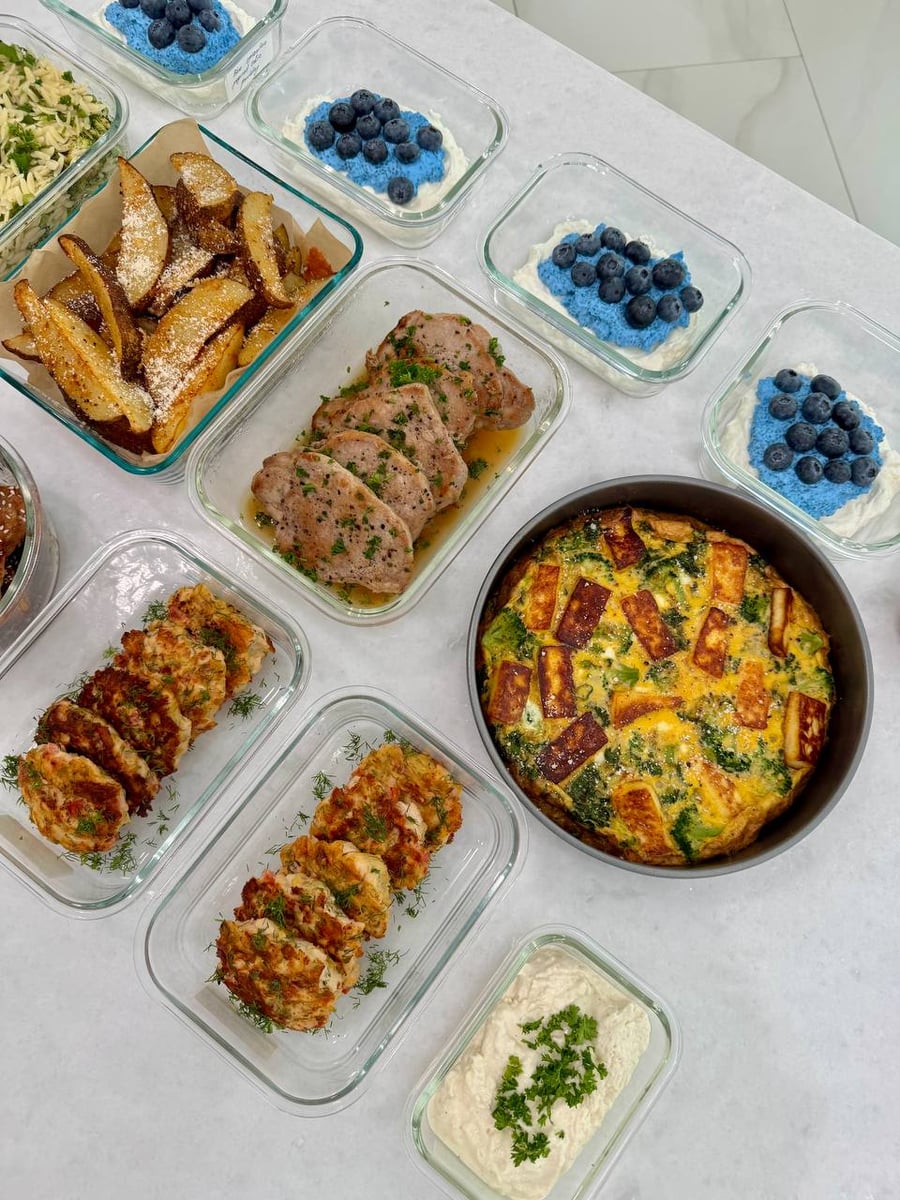 Parmesan-dusted potato wedges on parchment beside herbed pork chops, the frittata and dill patties filling the rest.