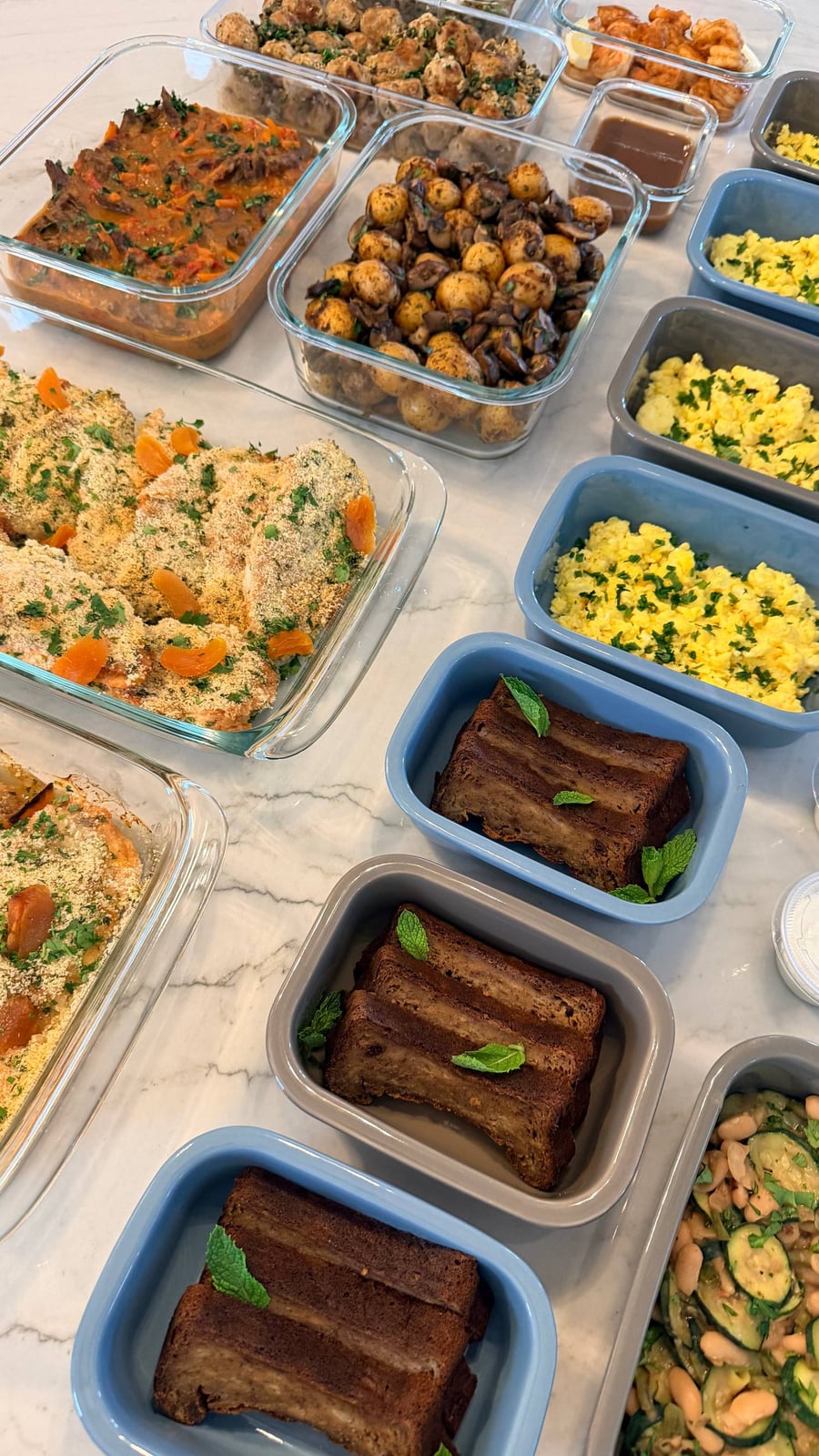 Ten dishes crowd the marble: apricot mustard chicken, chakhohbili stew, scrambled eggs and sliced banana bread.