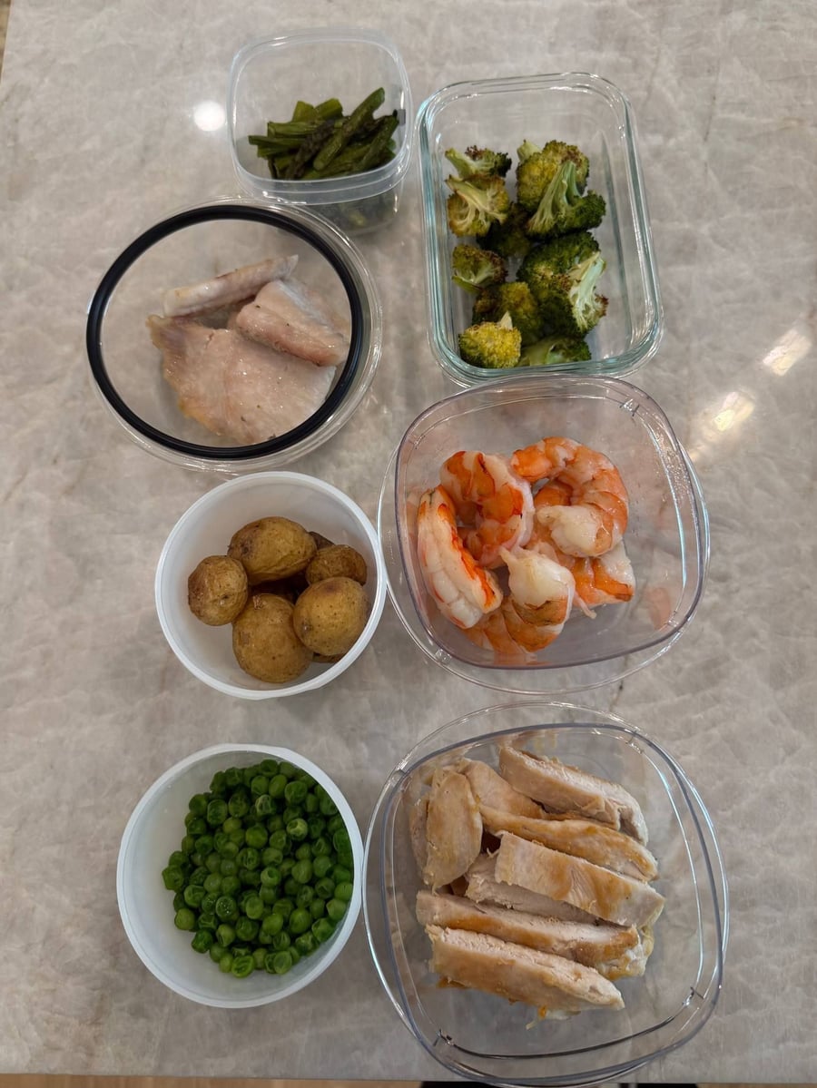 A child's portions laid out plain: sliced chicken, peeled shrimp, baby potatoes, peas, broccoli and asparagus.