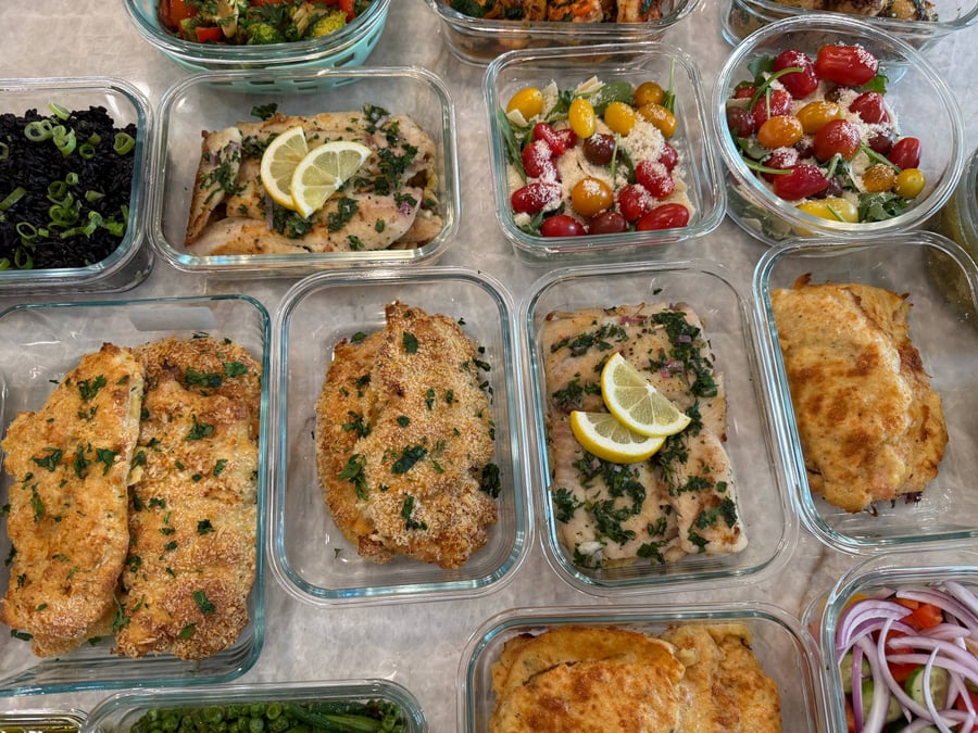 Black rice under sliced scallions sits beside lemon herbed flounder and two arugula parmesan tomato salads.