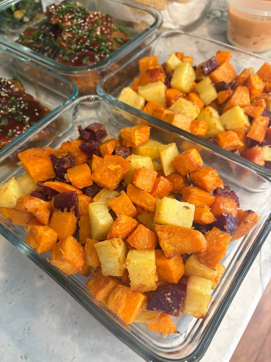 Purple, gold and orange sweet potato cubes crisped at the edges, teriyaki chicken waiting behind them.