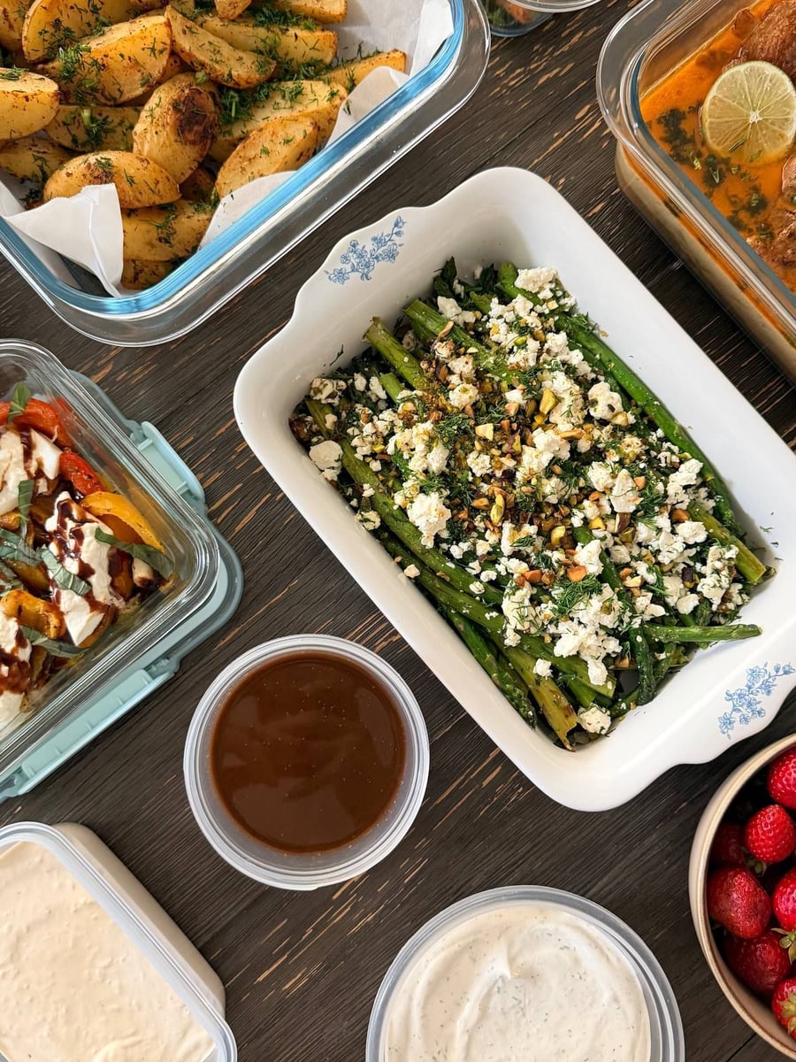 Dill flecks the potato wedges resting on parchment, pecan salmon above and three sauce tubs below.