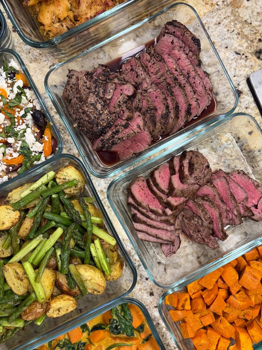 Asparagus batons and halved baby potatoes share one pan, dill freckling the browned cut faces.