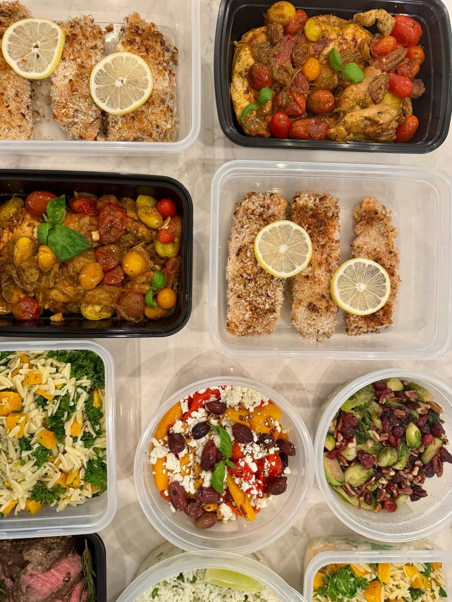 Panko and pecan crust sits pale gold on the salmon filets, pesto chicken tray sharing the counter.