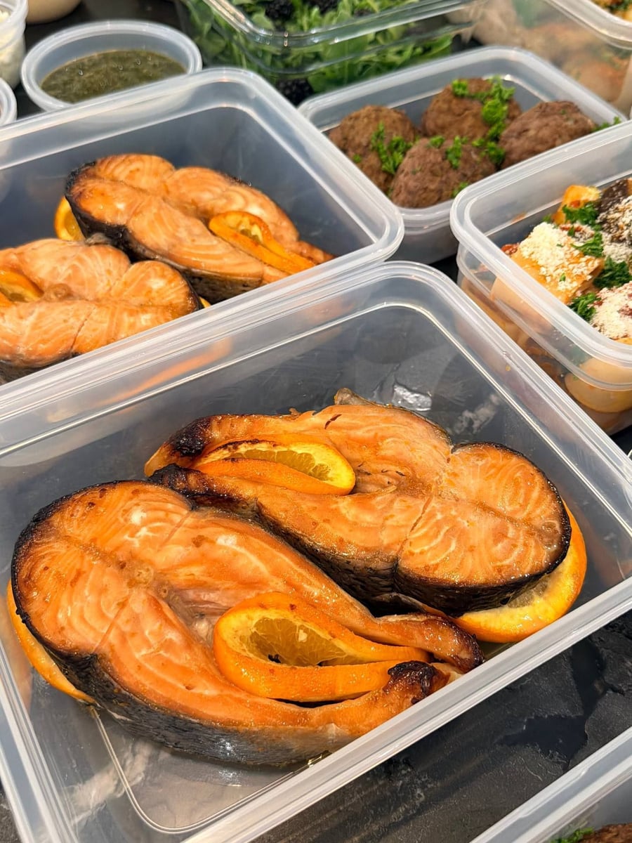 Orange slices tuck into the cavity of each salmon steak, the skin blistered dark around the rim.