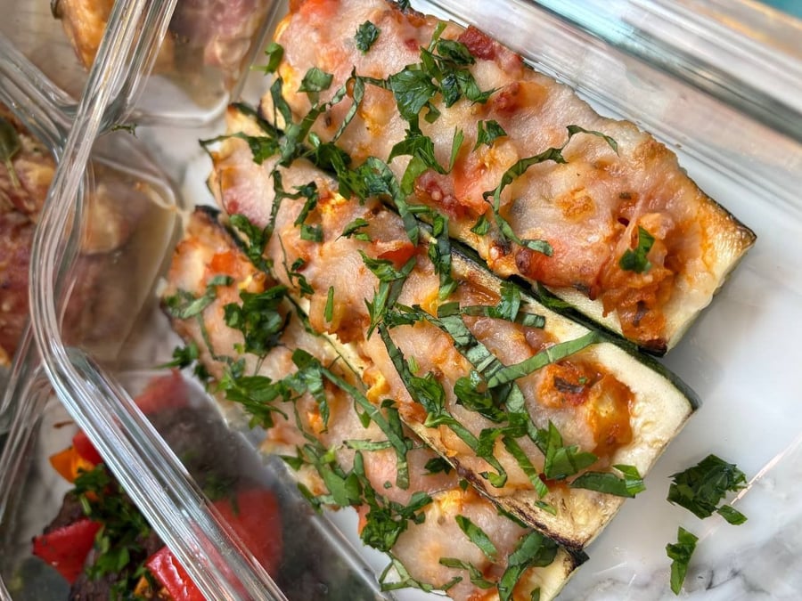 Sixteen containers step down the marble, kebobs and saltimboka at the top, plum salad at the foot.