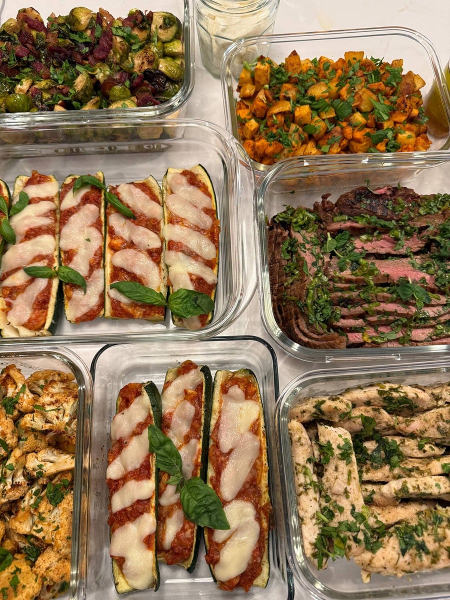Melted mozzarella stripes the tomato filled zucchini boats, whole basil leaves dropped over each one.