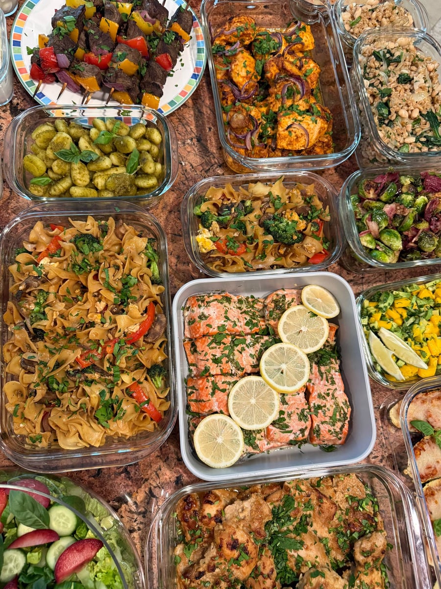 Twenty containers across cork: shawerma chicken, kebobs, salmon, gnocchi, farro and a plum salad.