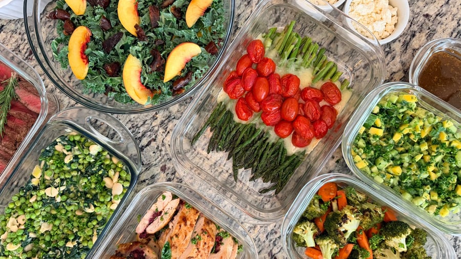Apricot wedges and chopped dates sit through the shredded kale, broccoli and stuffed chicken behind.