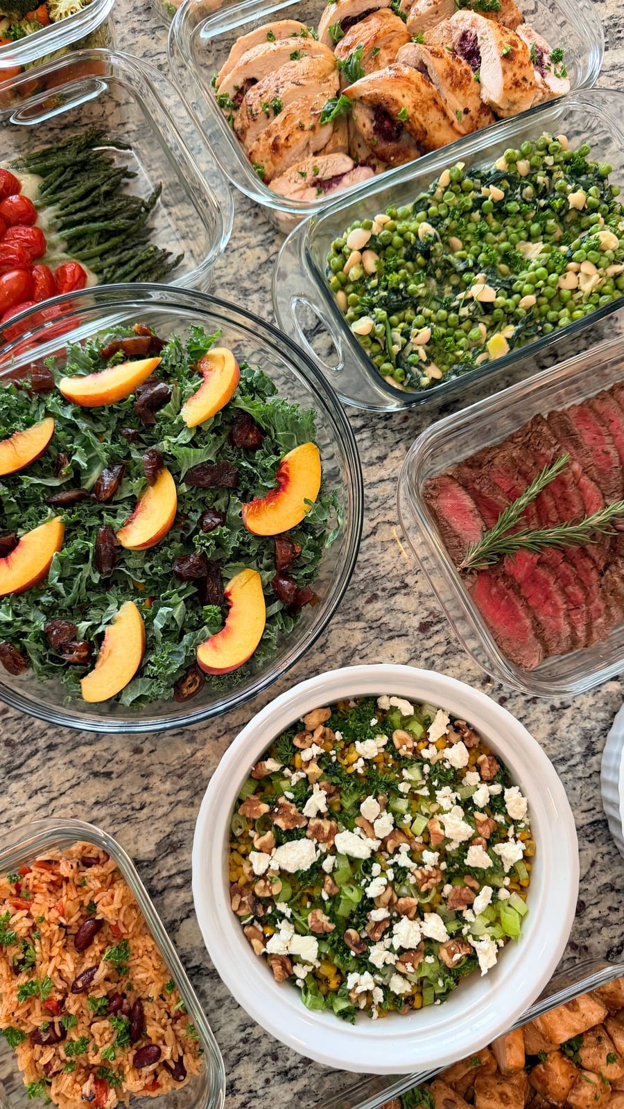 Rosemary rests on the filet mignon at the centre, stuffed chicken, spanish rice and kale salad around it.