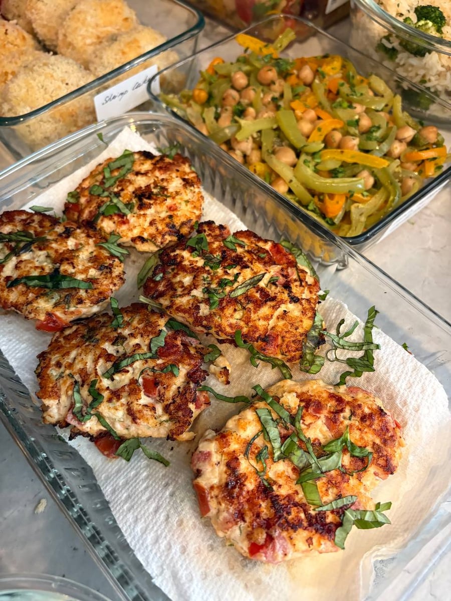 Thick panko coats every thai shrimp cake, grape tomatoes and butter beans catching light behind them.