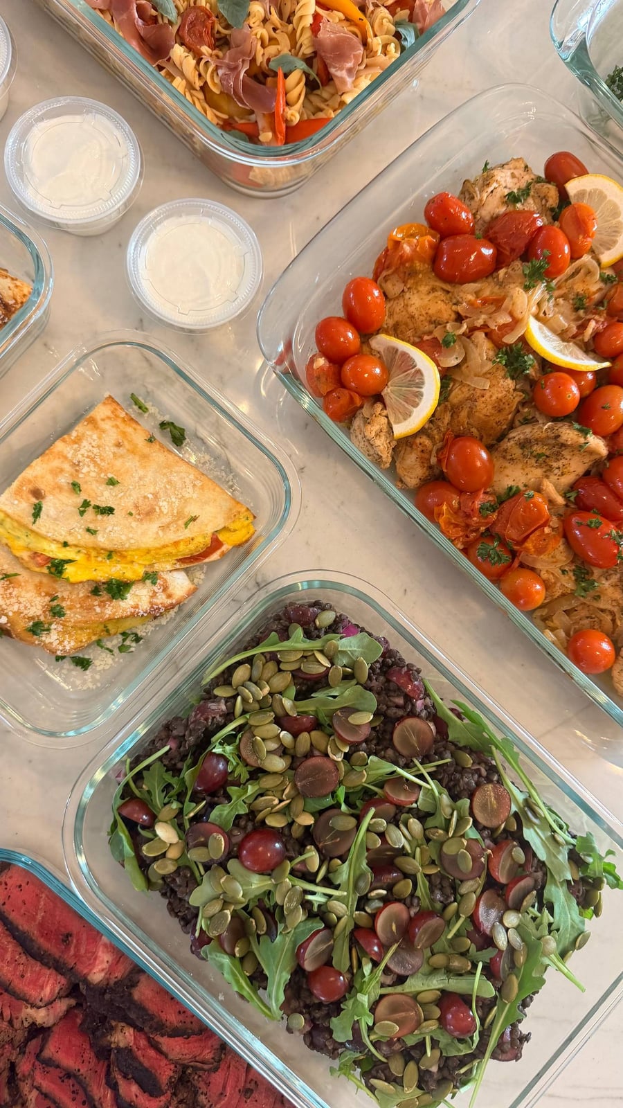 Halved grapes and pumpkin seeds scatter over black lentils and arugula, filet mignon at the edge.