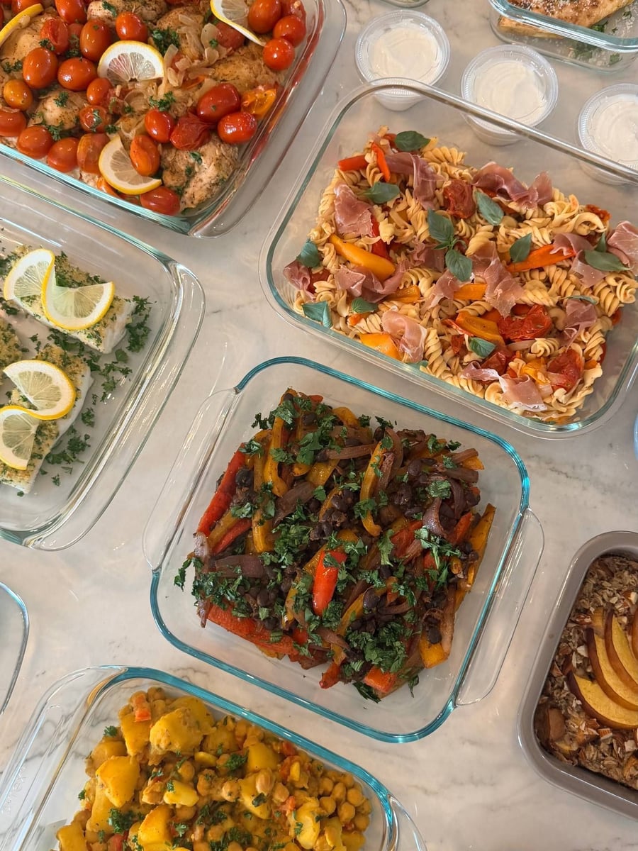 Zaatar dusted chicken sits under burst cherry tomatoes and lemon, chickpea pasta and fajita peppers alongside.