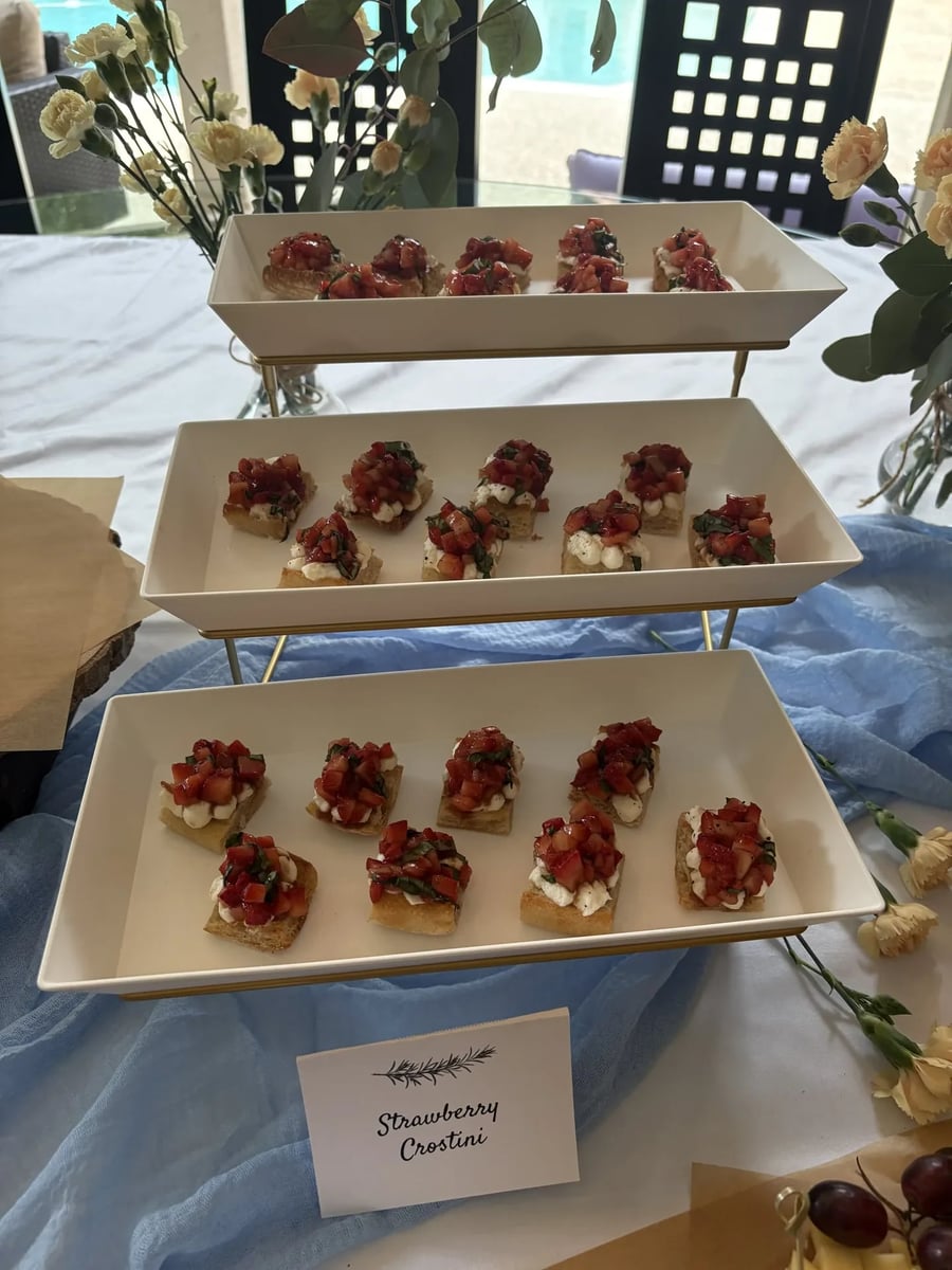 Whipped ricotta strawberry crostini on a three-tier gold stand with Strawberry Crostini label.