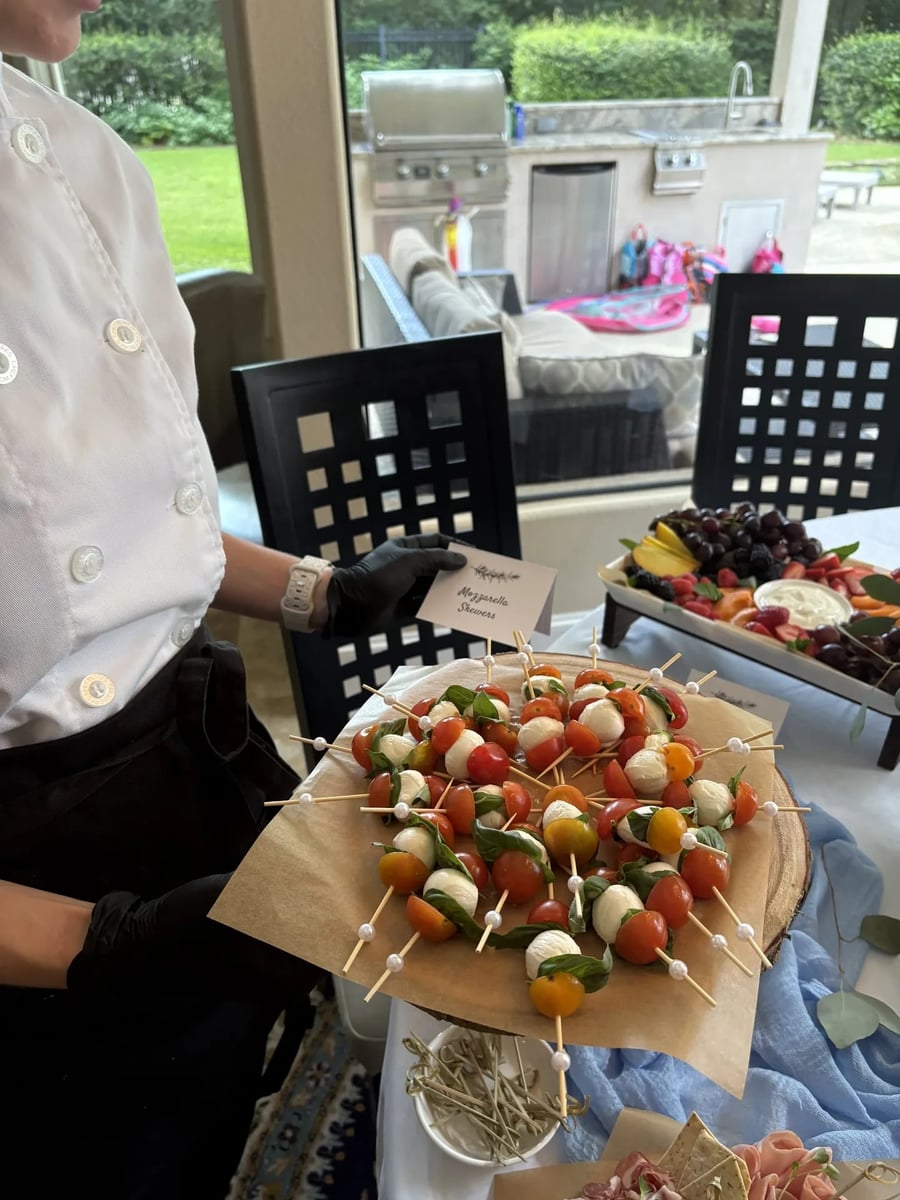 Fresh mozzarella and cherry tomato caprese skewers with fresh basil — label card visible.