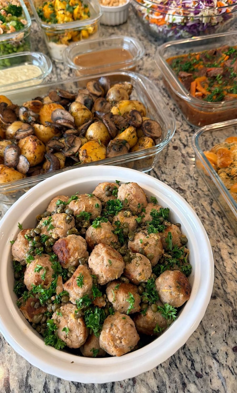 Sixteen dishes fill the counter, chakhohbili stew at the centre with slaw and quinoa either side.