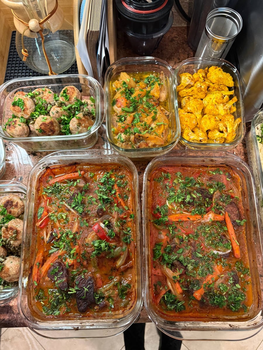 Two deep trays of beef chakhohbili stew sit below turkey picatta meatballs, apricot chicken and turmeric cauliflower.