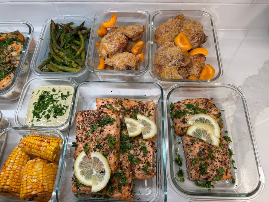 Everything bagel crusted salmon lies under lemon wheels beside panko apricot mustard chicken and charred asparagus.
