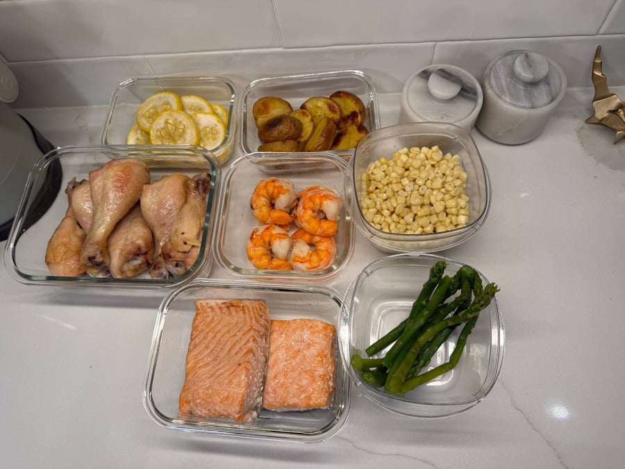 Plain baked drumsticks, peeled shrimp, corn kernels, salmon and zucchini coins portioned for the kids.