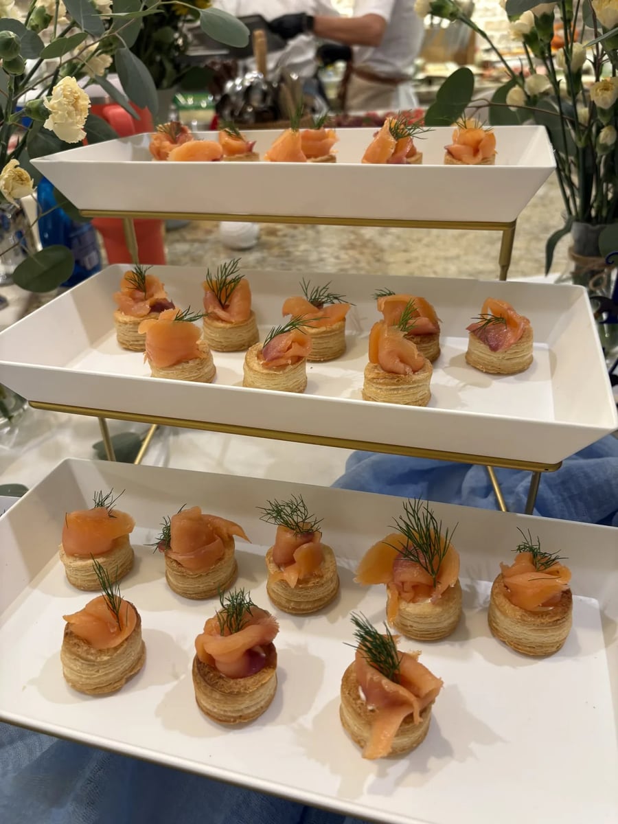 Smoked salmon vol-au-vent appetizer arranged on a tiered white and gold serving stand.
