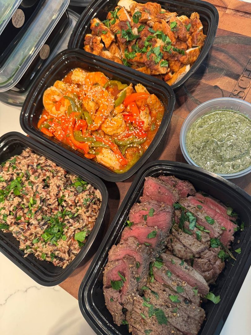 Assortment of prepared meals: chicken, shrimp, steak, rice, and pesto.