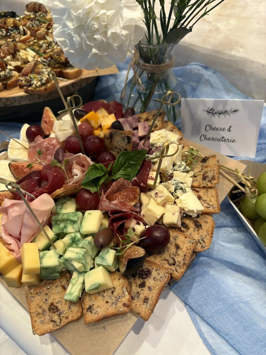 Artisan cheese and charcuterie selection with Gorgonzola, marble cheese, figs, and crackers.