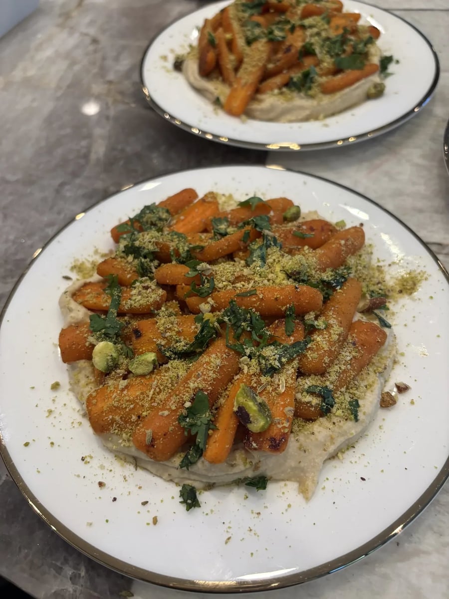 Honey-roasted baby carrots on whipped hummus with pistachio-fennel dukkah and fresh cilantro.