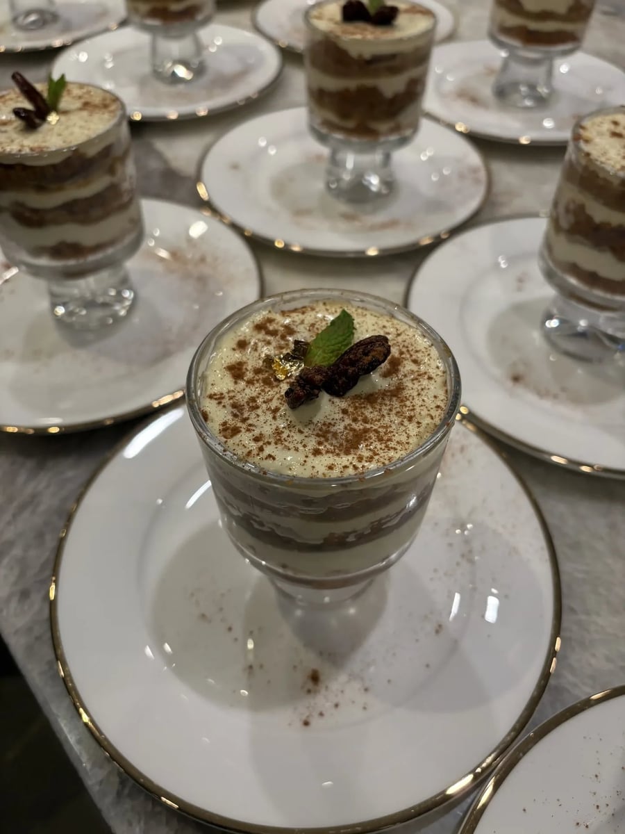 Spiced carrot cake verine in a parfait glass with cinnamon and dark garnish.