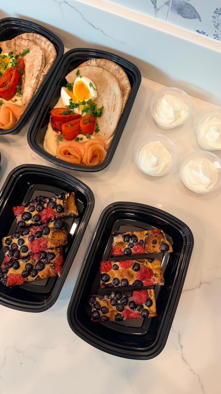 The selection includes balanced breakfast bowls featuring smooth hummus, tender smoked salmon, protein-rich boiled eggs, and toasted pita triangles.