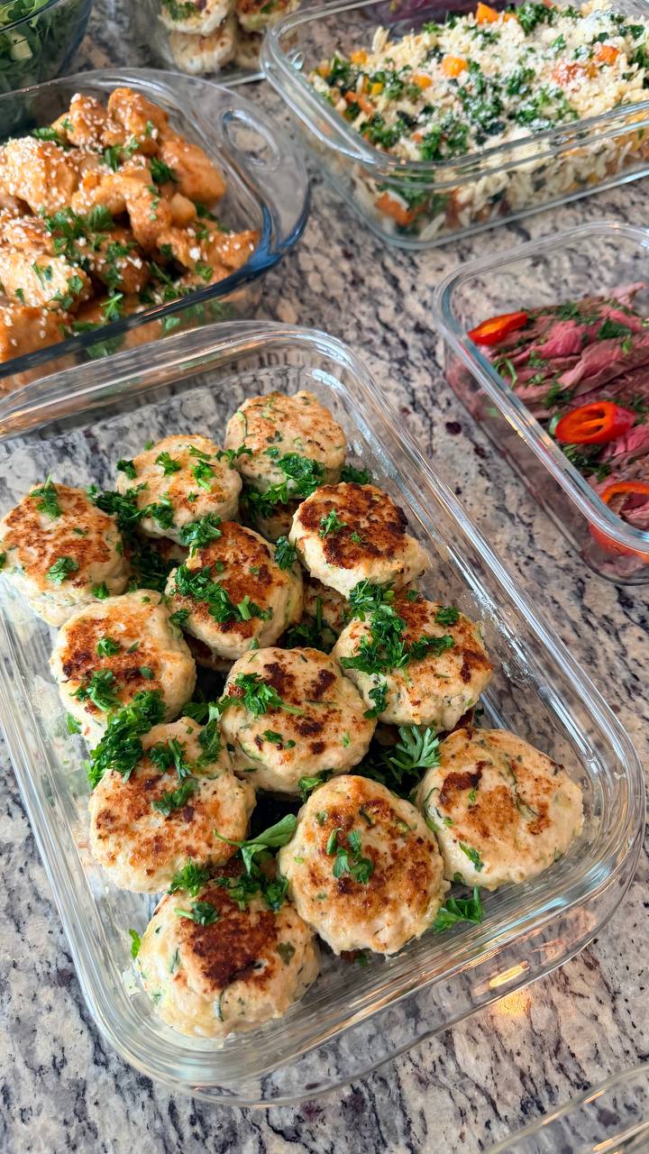 Golden-brown zucchini turkey fritters garnished with fresh herbs alongside orange glazed chicken and healthy rice orzo.