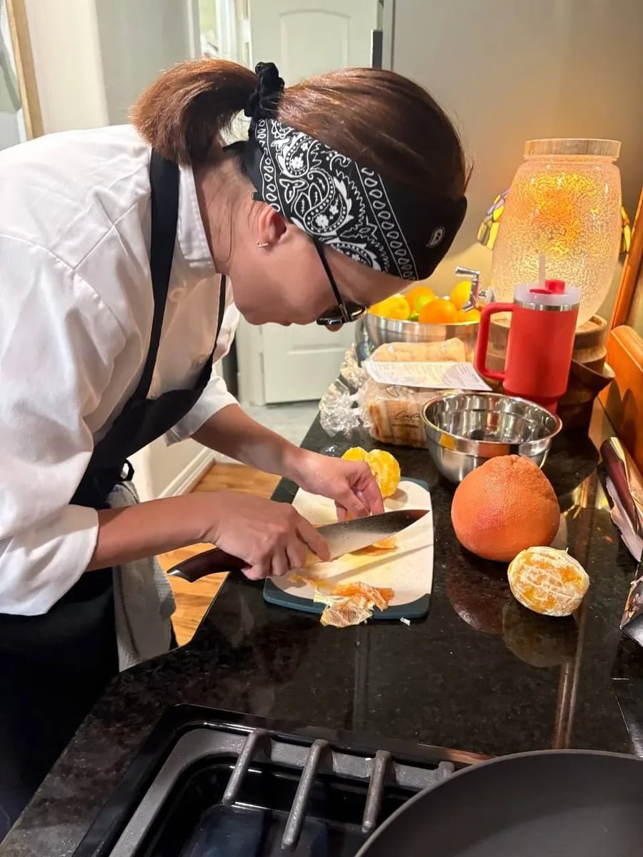Chef Ana preparing food at a kitchen counter during a private dinner