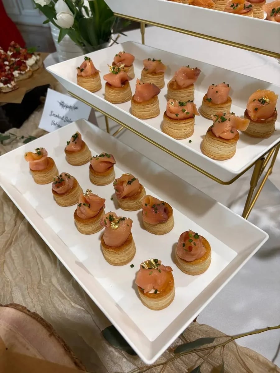 Smoked salmon vol-au-vent with crème cheese, chives, and gold leaf on flaky puff pastry shells.