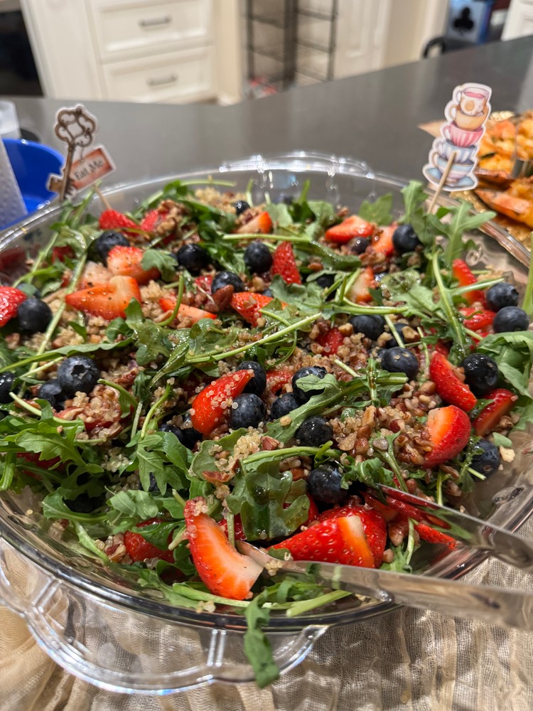 Arugula and strawberries salad with quinoa, blueberries, and pecans