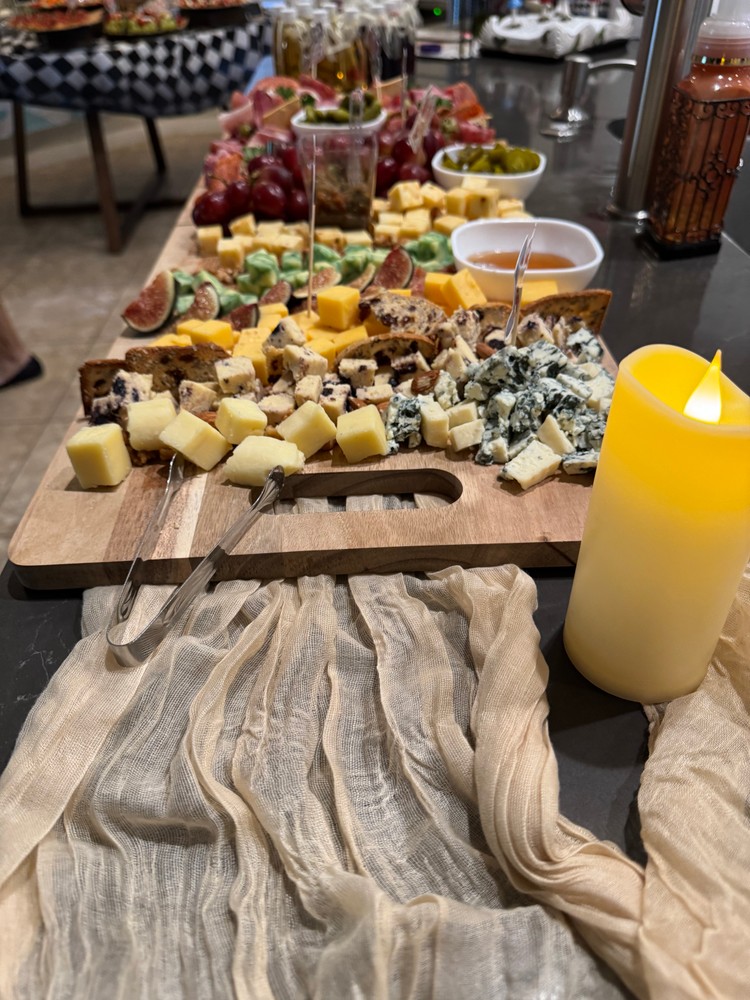 Cheese charcuterie board with candles and decorative fabric