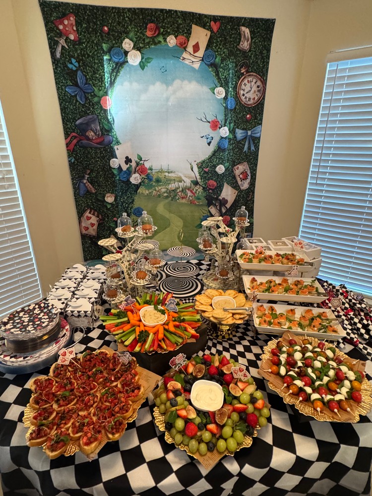 Appetizer buffet table with Alice in Wonderland theme.