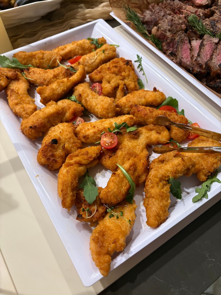 Crispy baked chicken tenders with cherry tomatoes and arugula
