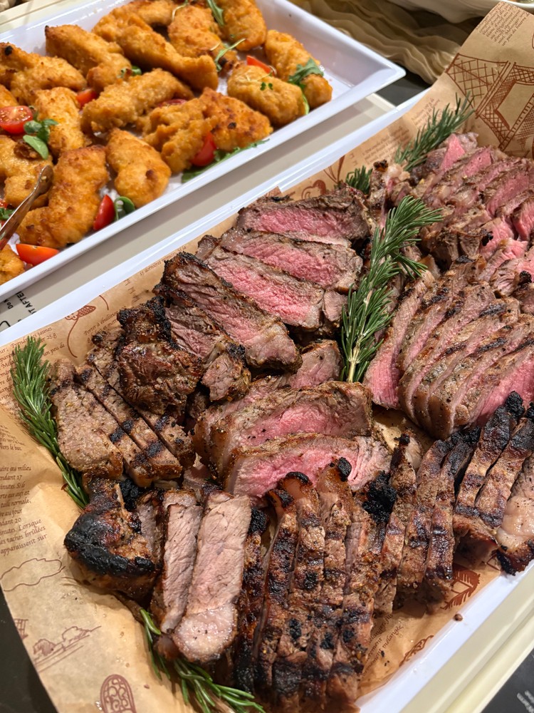 Sliced New York strip steaks with rosemary and crispy chicken tenders