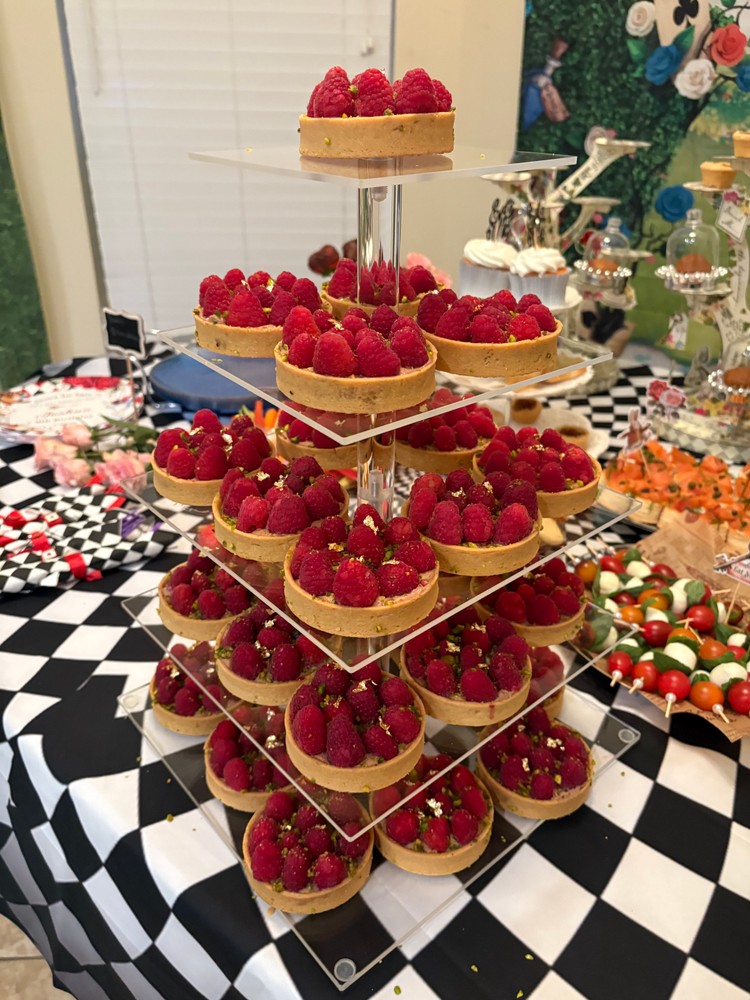 Tiered display of mini chocolate tarts with fresh raspberries