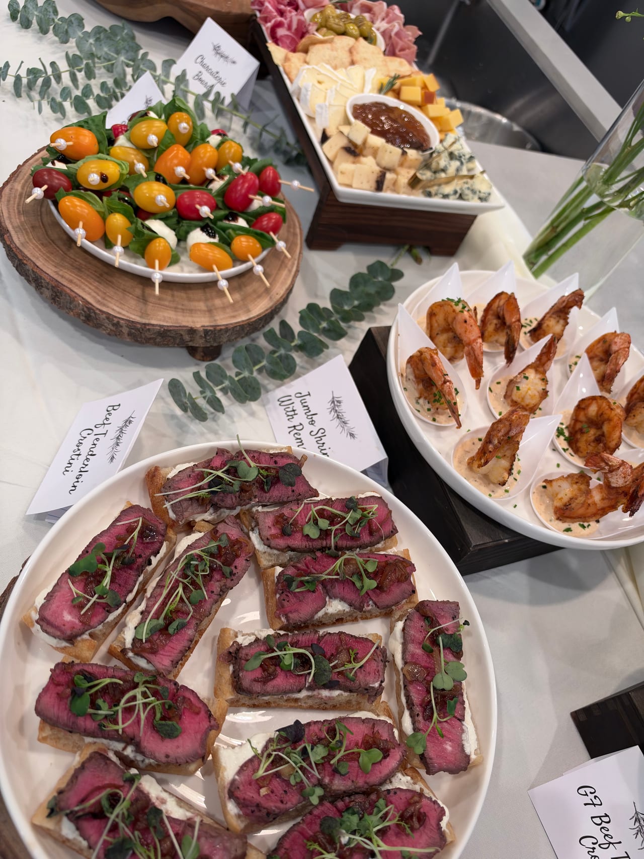 Beef crostini, shrimp and Caprese skewers arranged on separate platters.