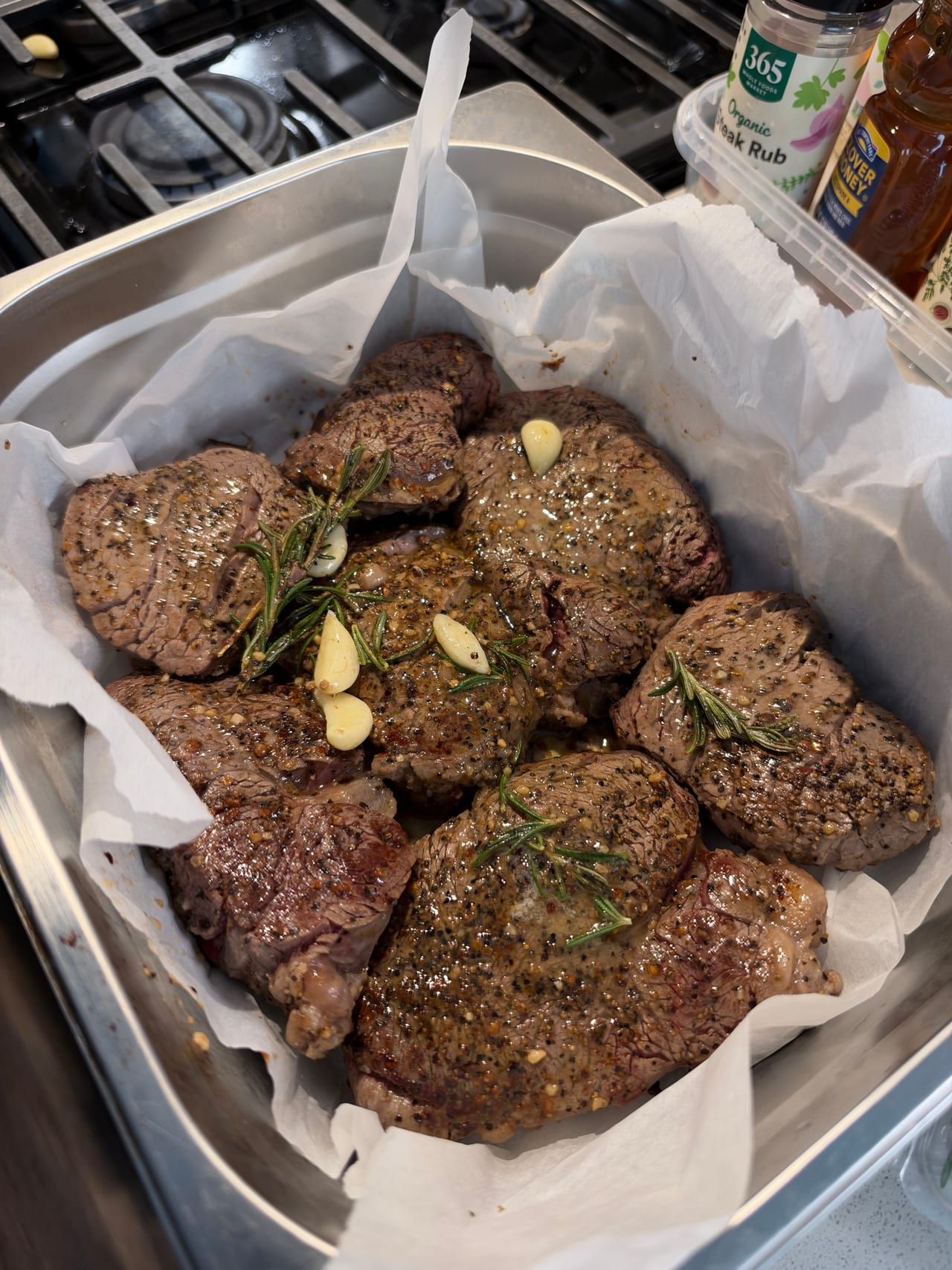 Braised beef pieces garnished with herbs in a lined service tray.