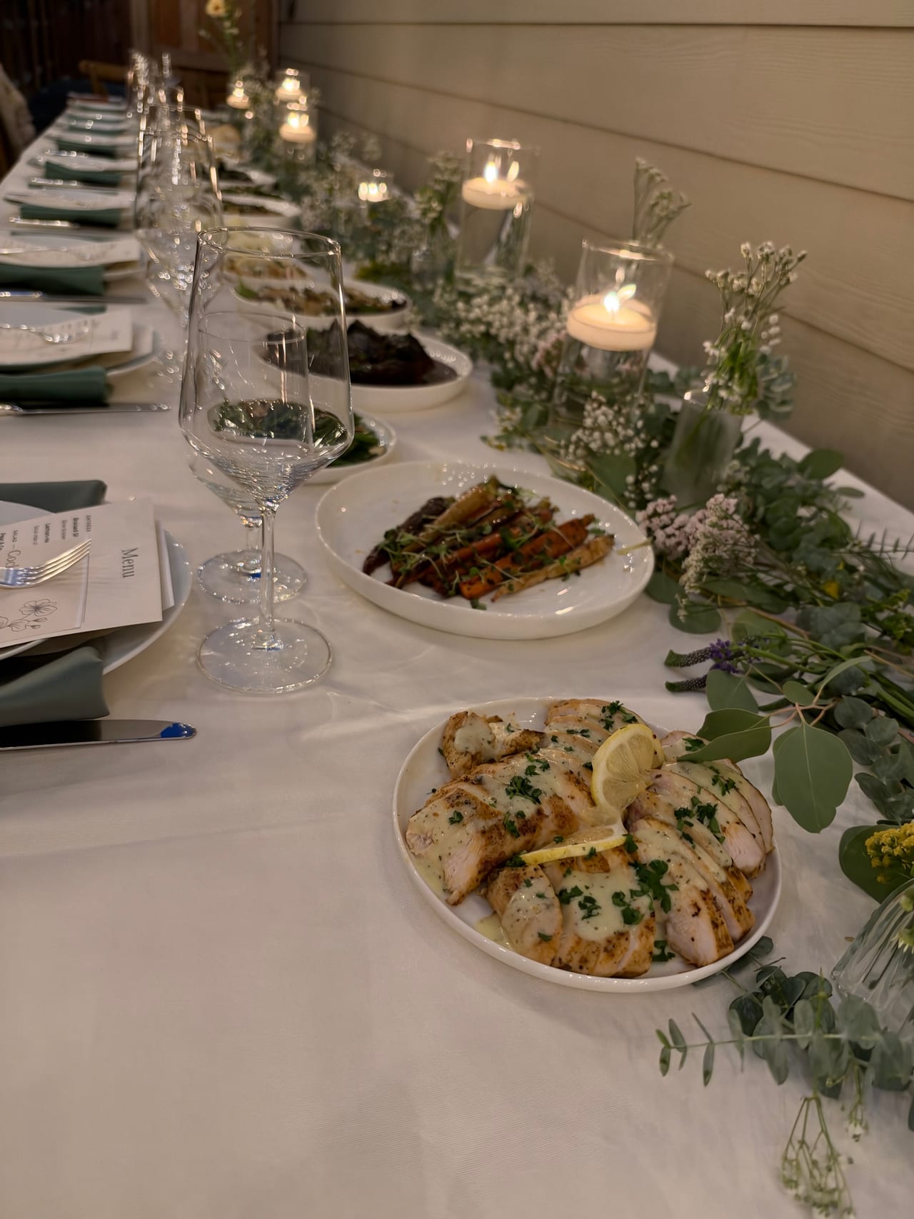 Dinner table with green salad, mashed potatoes and candles.