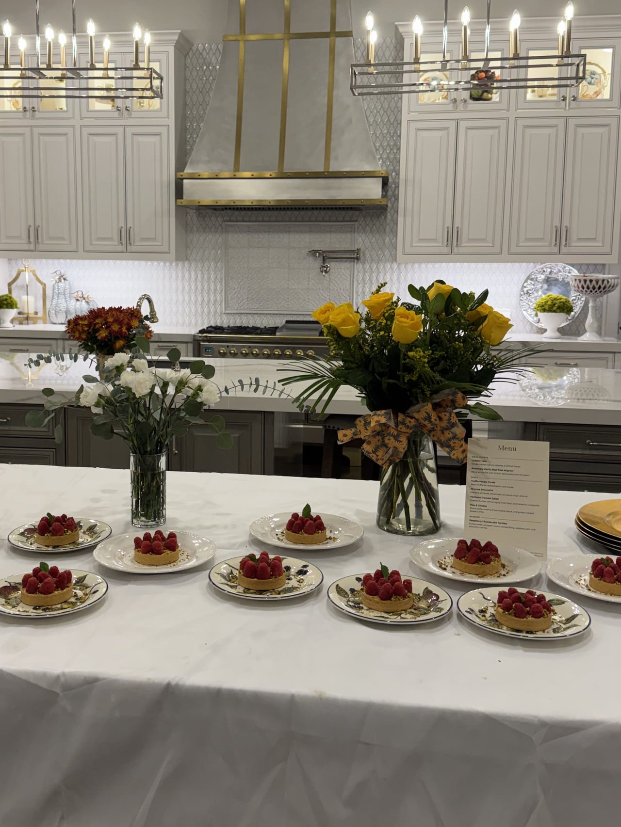 A kitchen island set with appetizers and individual raspberry tartlets.