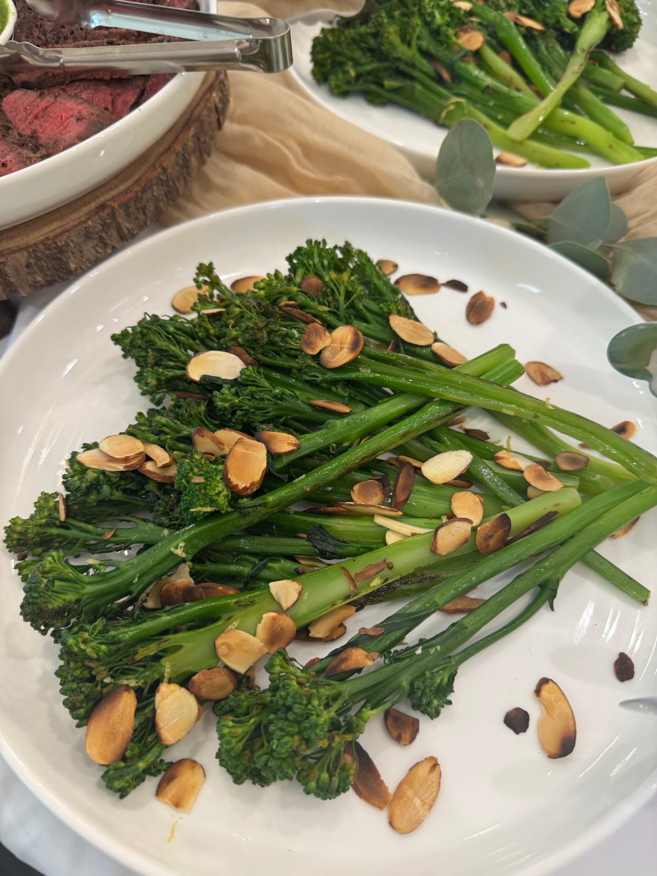 Broccolini topped with toasted almonds on a serving platter.