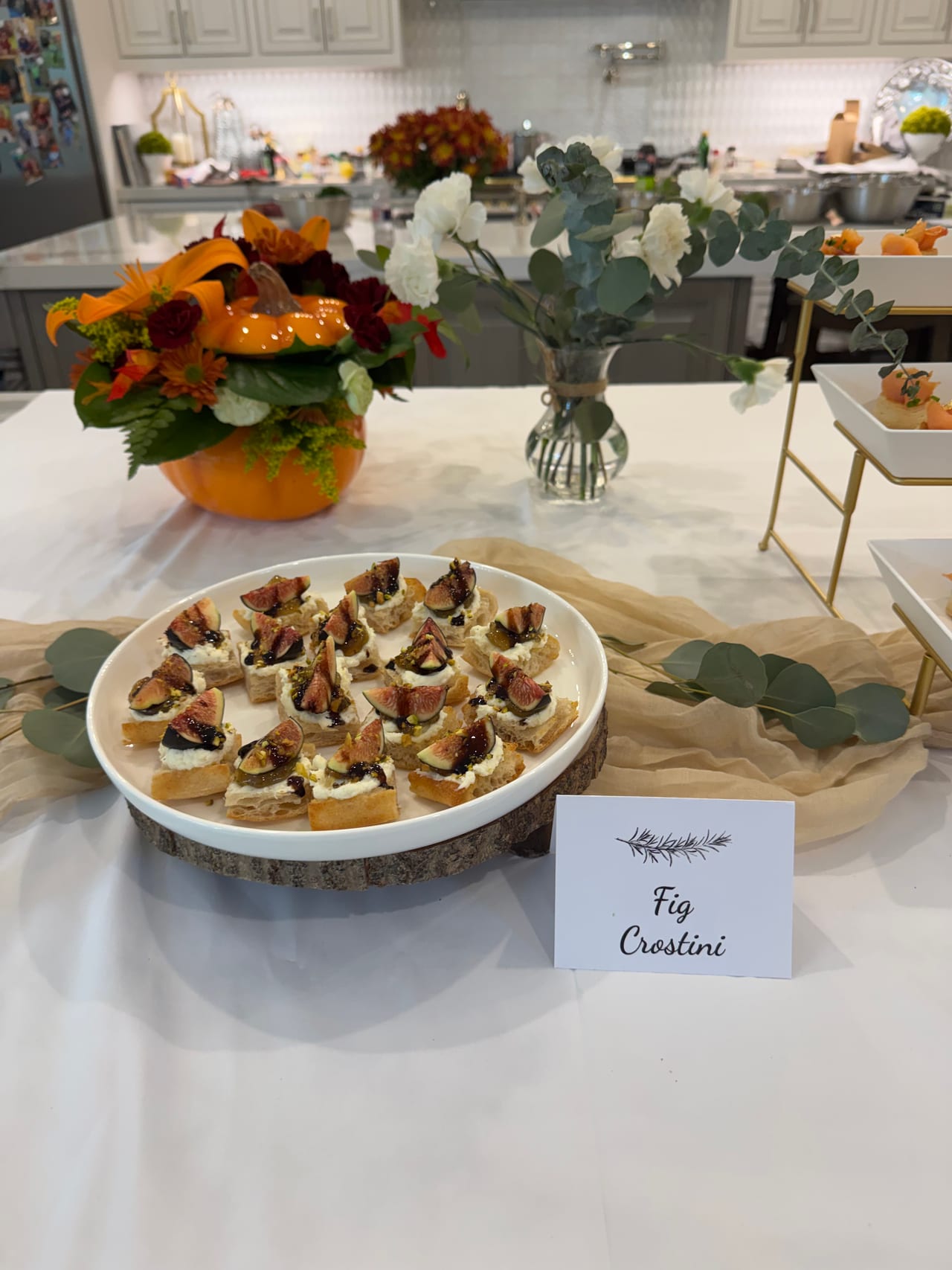 Fig crostini displayed on a white platter on the kitchen island.