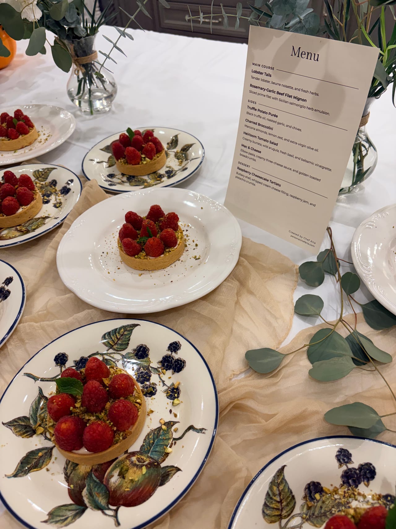 Raspberry tartlets displayed beside a printed dinner menu.