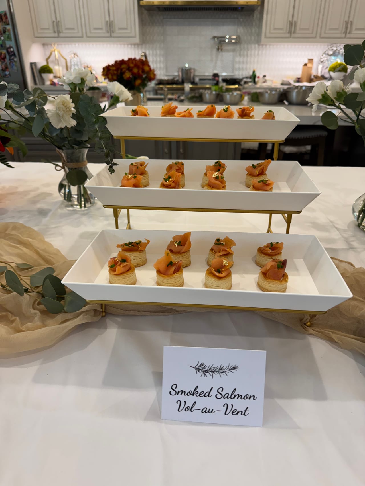 Smoked salmon pastries on a tiered white display.