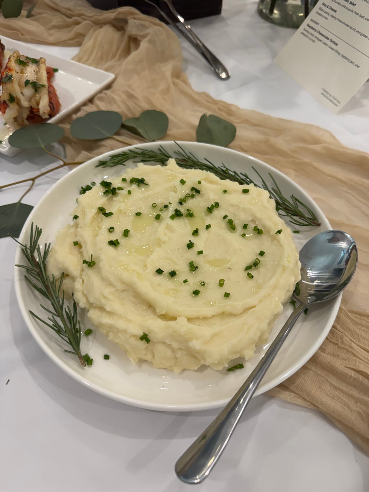 A bowl of smooth potato purée topped with chopped chives.