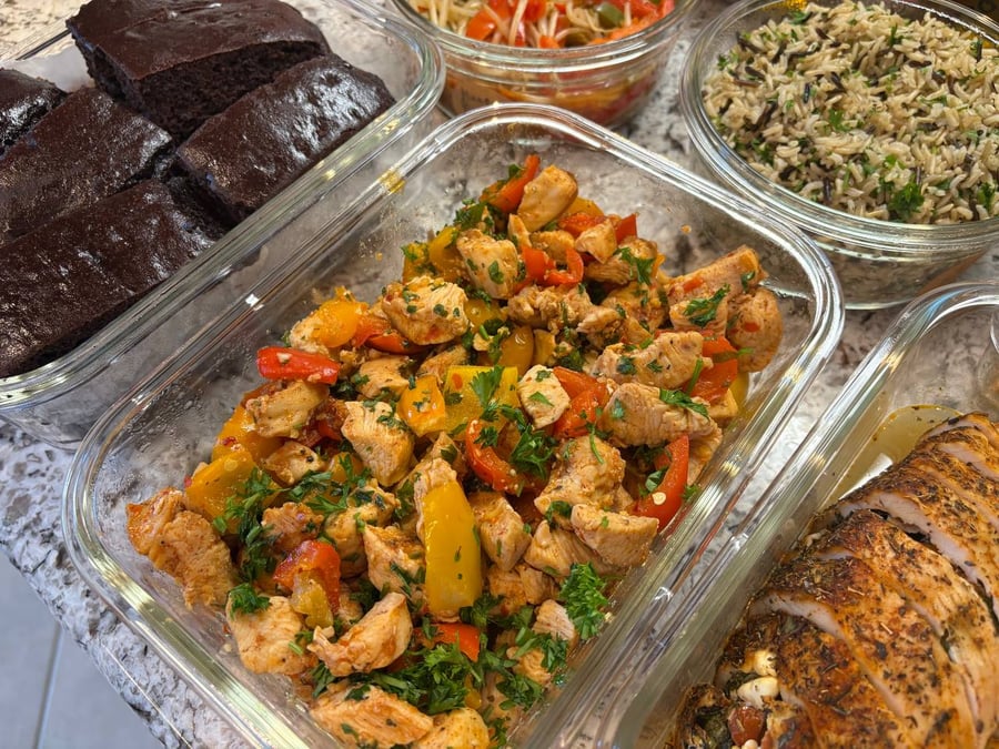 Glass meal prep containers filled with feta stuffed turkey tenderloin, sweet and sour chicken, rice, sprout stir-fry, and decadent protein brownies.